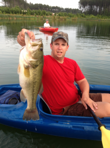 WaterWays resident  Tony Cravey holds up a bass caught in Grand Lagoon.